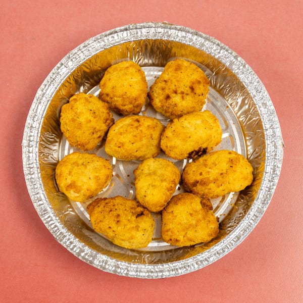 Ten golden-brown fried nuggets in a round silver foil container.